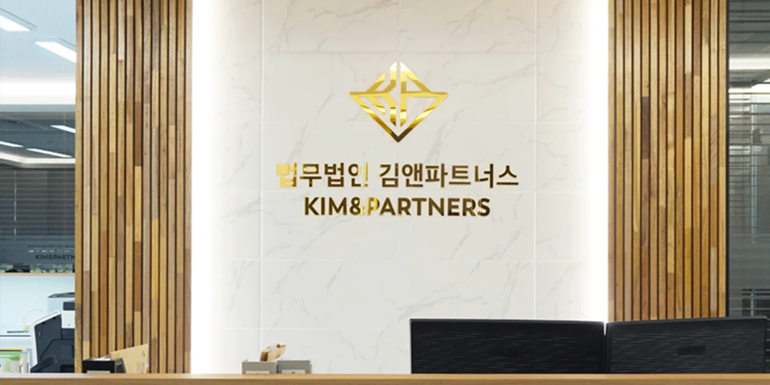 대리석 벽면에 금색으로 새겨진 법무법인 김앤파트너스 로고