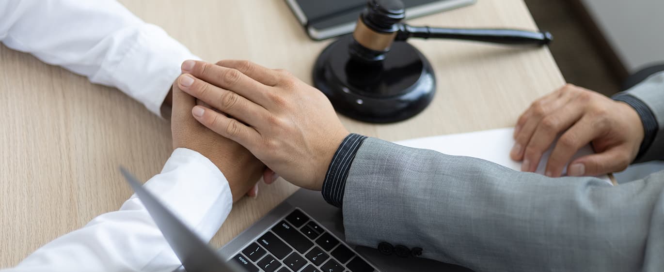 법인파산 상담 중 의뢰인의 손을 잡으며 격려하는 전문가