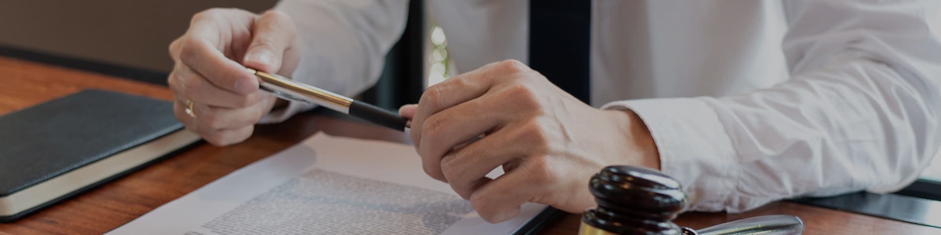 개인회생 서류를 검토하며 펜을 쥐고 있는 변호사의 손